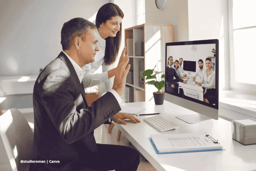 Hombre y mujer saludando en videoconferencia desde computadora de escritorio