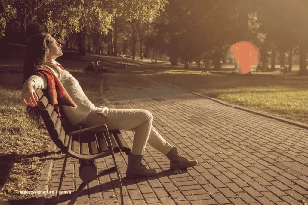 Mujer relajada en un parque con luz dorada.