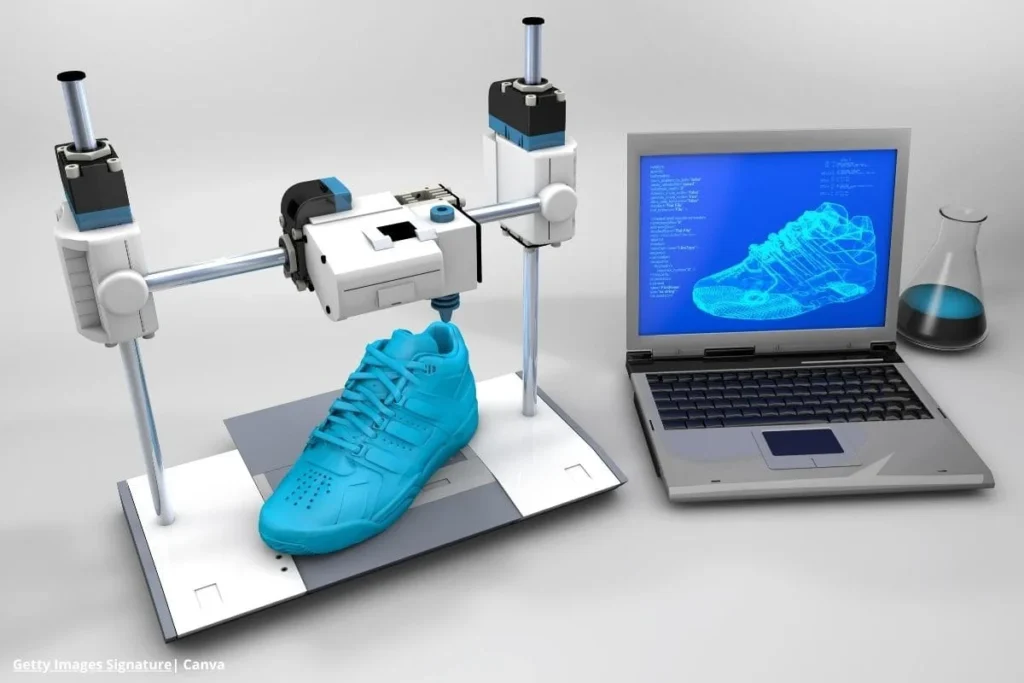 Zapatilla deportiva creada en impresión 3D junto a laptop con diseño digital