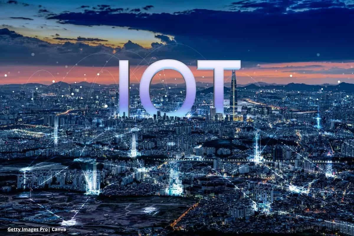 Vista aérea nocturna de una ciudad iluminada con líneas y puntos que representan la conectividad del IoT industrial en Colombia 2025
