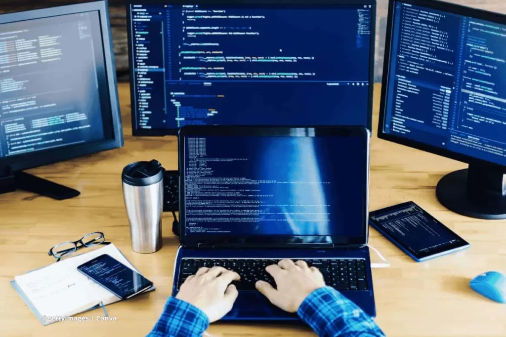 Programador trabajando con múltiples pantallas que muestran código relacionado con software de inteligencia artificial de NVIDIA.