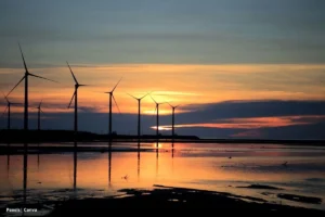 Energías renovables Colombia 2025 con aerogeneradores al atardecer en la costa.