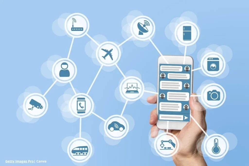 Mano sosteniendo un smartphone conectado a iconos de diferentes sectores que simbolizan el IoT industrial