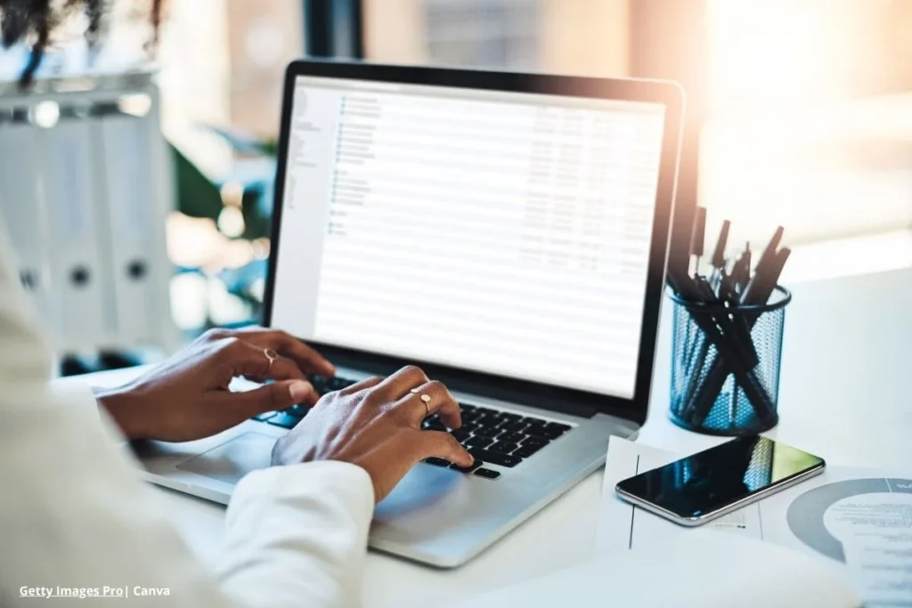 Manos escribiendo en portátil en contexto de outsourcing TI.