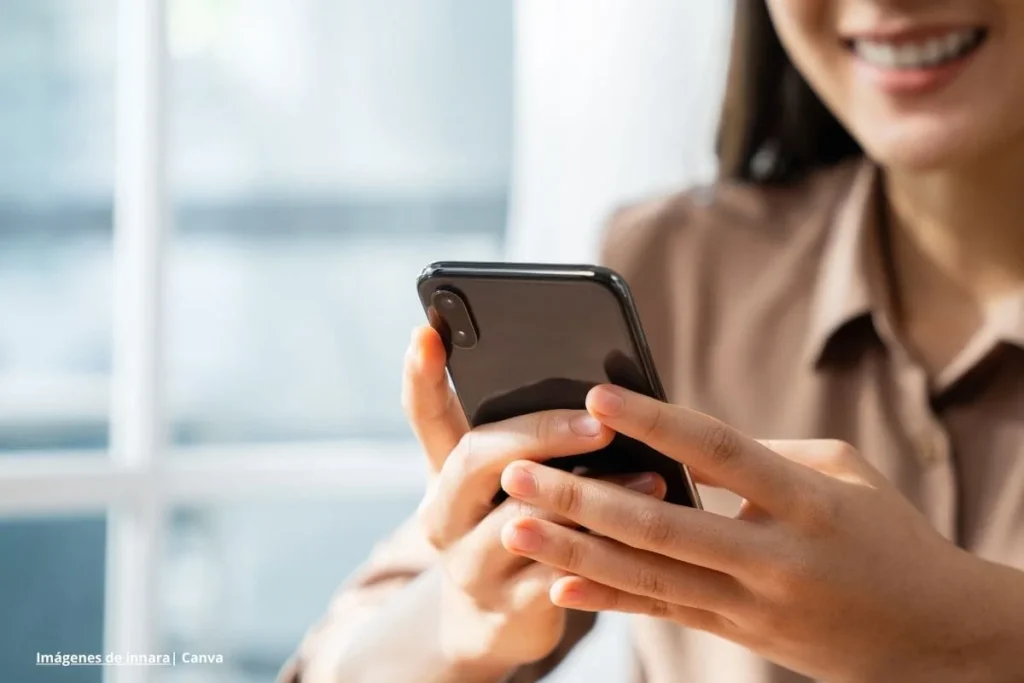 El 5G en Colombia 2025: redefiniendo la industria, la salud y el entretenimiento 3 Conectividad móvil: mujer usa smartphone en interior, primer plano de manos.