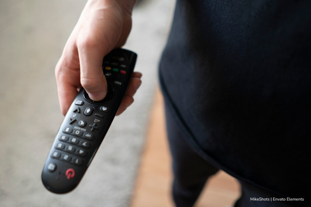 mejores apps IPTV, persona usando control remoto, Más Tecnología